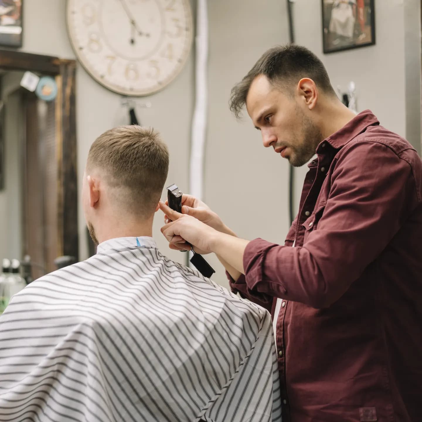 Berberin šiša klijenta mašinicom u salonu